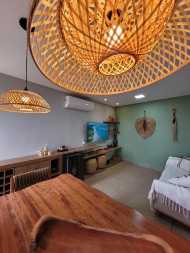 a dining room with a large wooden table and lights at Bahia Soul - Casa Bambu - Barra Grande - Península de Maraú in Barra Grande