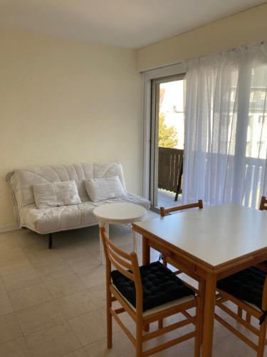 un salon avec un canapé, une table et des chaises dans l'établissement Beau 2P à Deauville avec balcon, à La Celle-sous-Gouzon