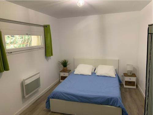 a bedroom with a bed with blue sheets and a window at Le Cyprès in Saint-Mitre-les-Remparts
