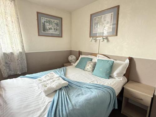 a bedroom with a bed with blue and white pillows at The Aberford in Blackpool
