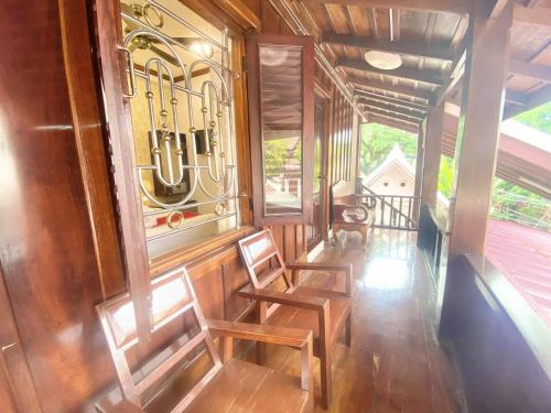 two chairs in a room with a window at Luangprabang Villa Suan Keo Two in Luang Prabang