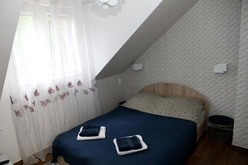 a bedroom with a bed with two towels on it at Pensjonat E&M in Mikołajki
