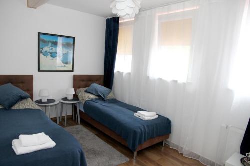 a bedroom with two beds and a window at Pensjonat E&M in Mikołajki