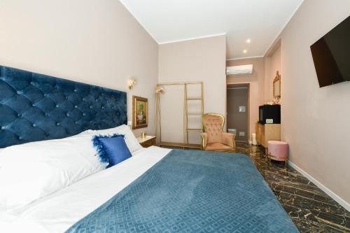 a bedroom with a large bed with a blue headboard at Prestige Suite Via Romagnoli in Sirmione