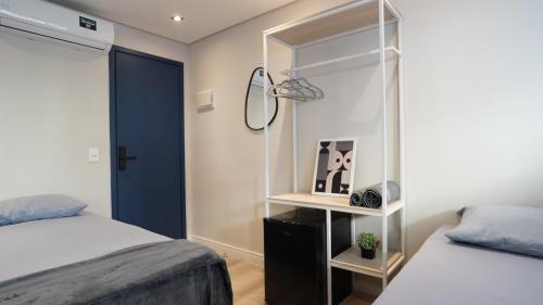 a bedroom with two beds and a blue door at Studios Mood - Unidade Mackenzie in Sao Paulo
