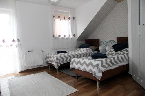 a room with three beds and a staircase at Pensjonat E&M in Mikołajki