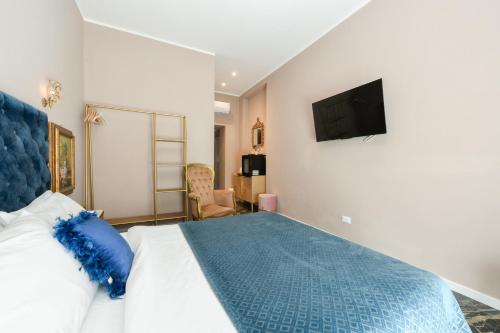 a bedroom with a bed and a tv on the wall at Prestige Suite Via Romagnoli in Sirmione