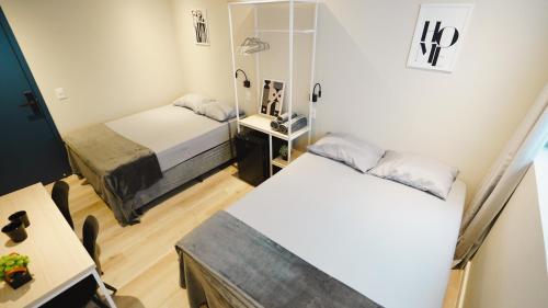 a small room with two beds and a mirror at Studios Mood - Unidade Mackenzie in Sao Paulo