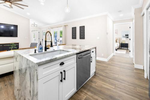 a kitchen with white cabinets and a sink at Alluring Luxury Oasis, Modern Comfort & Relaxation in Wellington