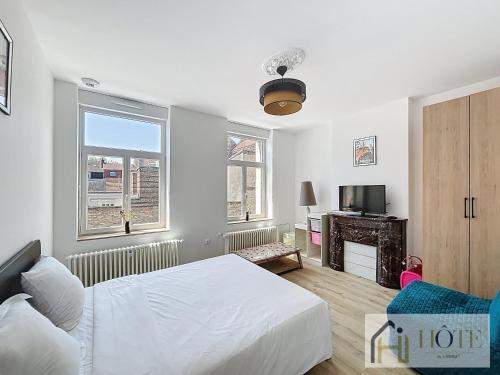 une chambre blanche avec un lit et une télévision dans l'établissement Spacieux 1 Chambres avec Terrasse, 50m de la Plage, à Dunkerque