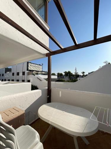 a white table and chairs on a balcony with a view at La Cassia in Cabo Negro