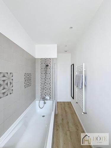 une salle de bain blanche avec une baignoire et une douche dans l'établissement Spacieux 1 Chambres avec Terrasse, 50m de la Plage, à Dunkerque
