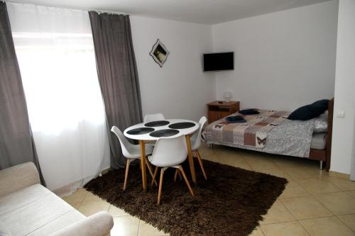 a room with a table and chairs and a bed at Pensjonat E&M in Mikołajki