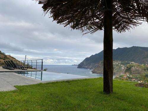 a view of a body of water with a bench at Penha D'Águia Villa in Porto da Cruz