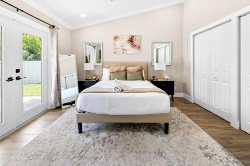 a bedroom with a large bed and two windows at Alluring Luxury Oasis, Modern Comfort & Relaxation in Wellington