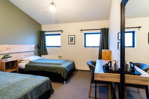 a hotel room with two beds and a desk at Adventure Hotel Hof in Hof
