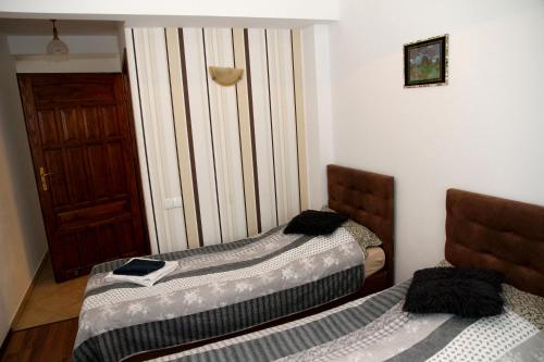 two beds sitting in a room with a door at Pensjonat E&M in Mikołajki
