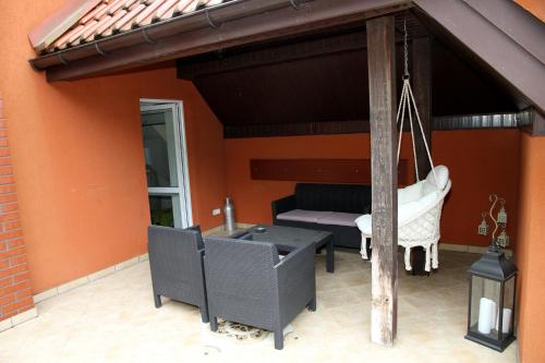 a patio with a couch and a table and chairs at Pensjonat E&M in Mikołajki