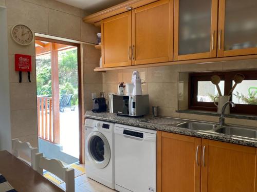 a kitchen with a washing machine and a sink at Penha D'Águia Villa in Porto da Cruz