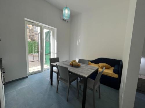 a room with a table and a couch with a dog on it at Otranto - appartamento sul mare, parcheggio privato in Otranto