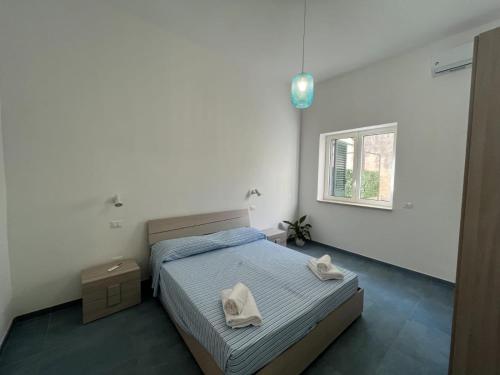 a bedroom with a bed with two towels on it at Otranto - appartamento sul mare, parcheggio privato in Otranto