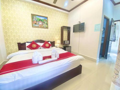 a bedroom with a large bed with a red blanket at Luangprabang Villa Suan Keo Two in Luang Prabang