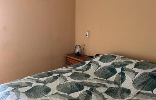 a bedroom with a bed with a green and white comforter at Chalet de Sudhoek in Vrouwenparochie