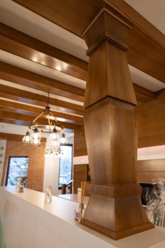 a kitchen with a wooden ceiling and a large pillar at Casa Danciu in Fînaţe