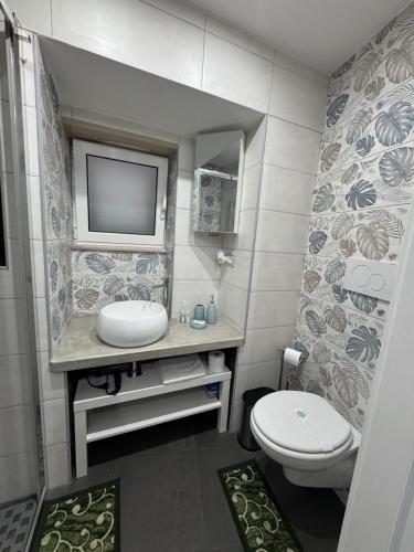 a bathroom with a toilet and a tv on the wall at Semplice Dimora Ostuni in Ostuni