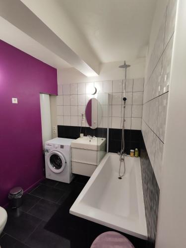 a bathroom with a white tub and a washing machine at Center of Lille, spacious & cozy apartment in Lille