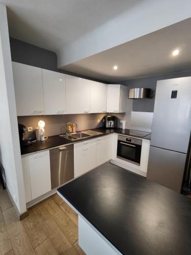 une cuisine avec des armoires blanches et un comptoir noir dans l'établissement Center of Lille, apartment with garage, à Lille