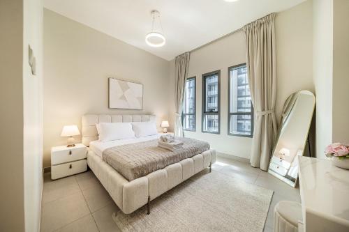 a bedroom with a large bed and two windows at Luxury unit in the Heart of Dubai Hills in Dubai