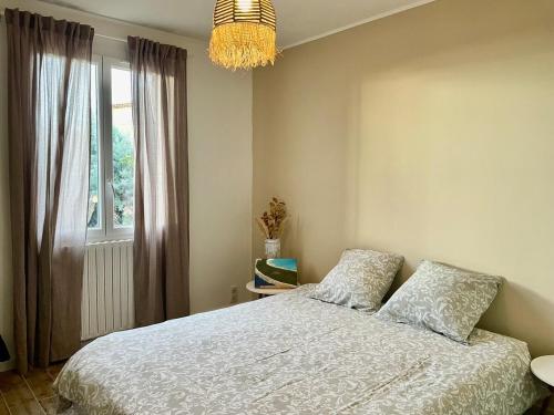 une chambre avec un lit, une fenêtre et un lustre dans l'établissement Villa Marthe, maison rénovée avec terrasses, piscine et vue sur le village d'Aups, à Aups