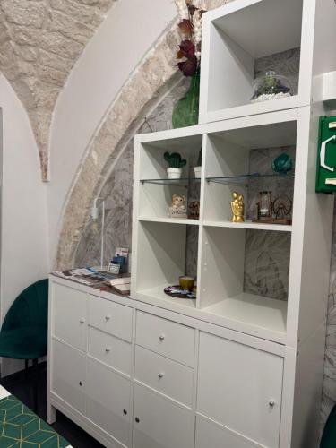 a white dresser in a room with a stone wall at Semplice Dimora Ostuni in Ostuni