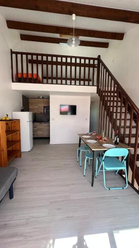 un salon avec une table et un escalier dans l'établissement Belle vue sur l Herault et les bateaux, à Agde