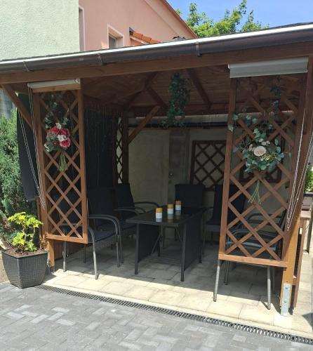 a pergola with a table and chairs under it at Ferienwohnung Classic in Radeberg