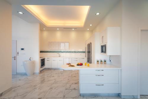 a large kitchen with white cabinets and marble floors at Apartment Magical View in Jerusalem