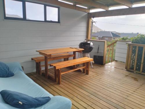 a patio with a table and a bench on a deck at C es Cape in Pringle Bay