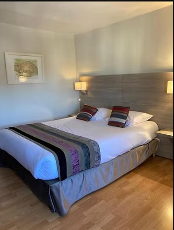 une chambre avec un grand lit avec deux oreillers dans l'établissement Hôtel de la Poste Restaurant Benjamin Linard, à Pouilly-en-Auxois