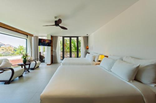 a hotel room with two beds and a balcony at Shoreline Stay in Hoi An