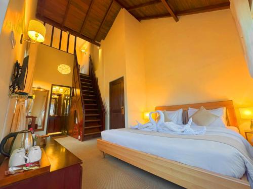 a bedroom with a large bed and a staircase at The Tapherini Bungalow in Nuwara Eliya