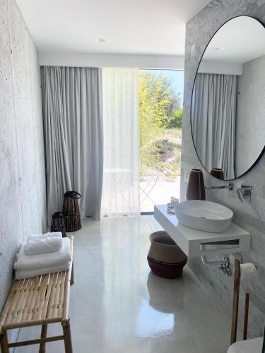 a white bathroom with a sink and a mirror at White Olive Villas in Santarém