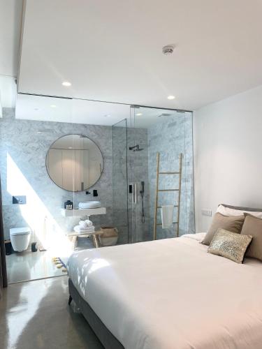 a bedroom with a large bed and a glass shower at White Olive Villas in Santarém