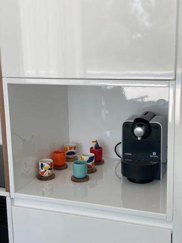 a toy kitchen with cups and a toaster on a shelf at White Olive Villas in Santarém