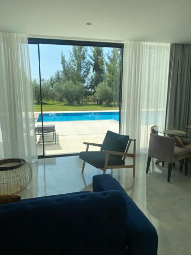 a living room with a view of a swimming pool at White Olive Villas in Santarém
