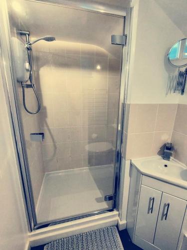 a bathroom with a shower and a sink at Holm Cottage near Charlestown in St Austell