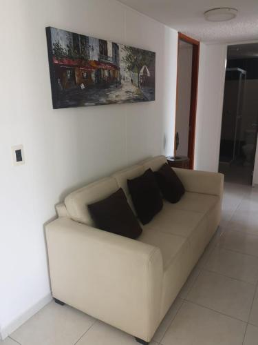 a white couch in a living room with two pillows at Habitar de Asis in Bucaramanga