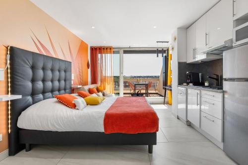 une chambre avec un grand lit aux murs orange dans l'établissement Village Naturiste R4N - Will4Stay Sea View, au Cap d'Agde