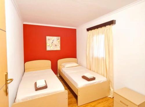 two beds in a small room with red walls at Villa Nikolas by PosarelliVillas in Vamos
