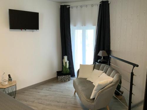 un salon avec un canapé et une télévision dans l'établissement les gites de KALY, à Bélesta